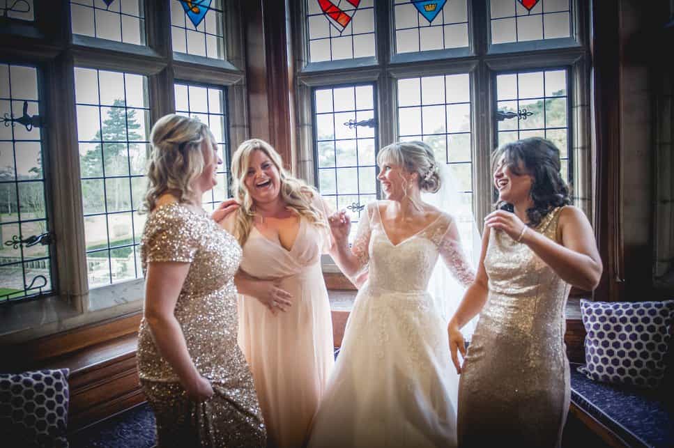 Bride laughing with bridesmaids, wearing gold sequinned dresses