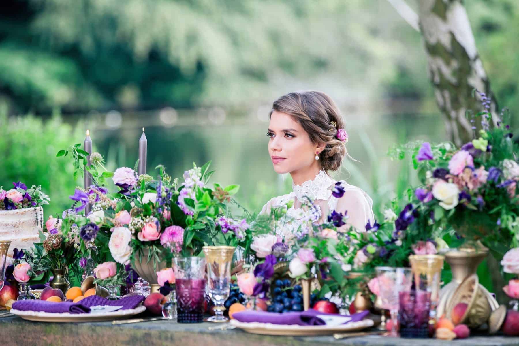Bridal model seated at table among pink and purple flowers