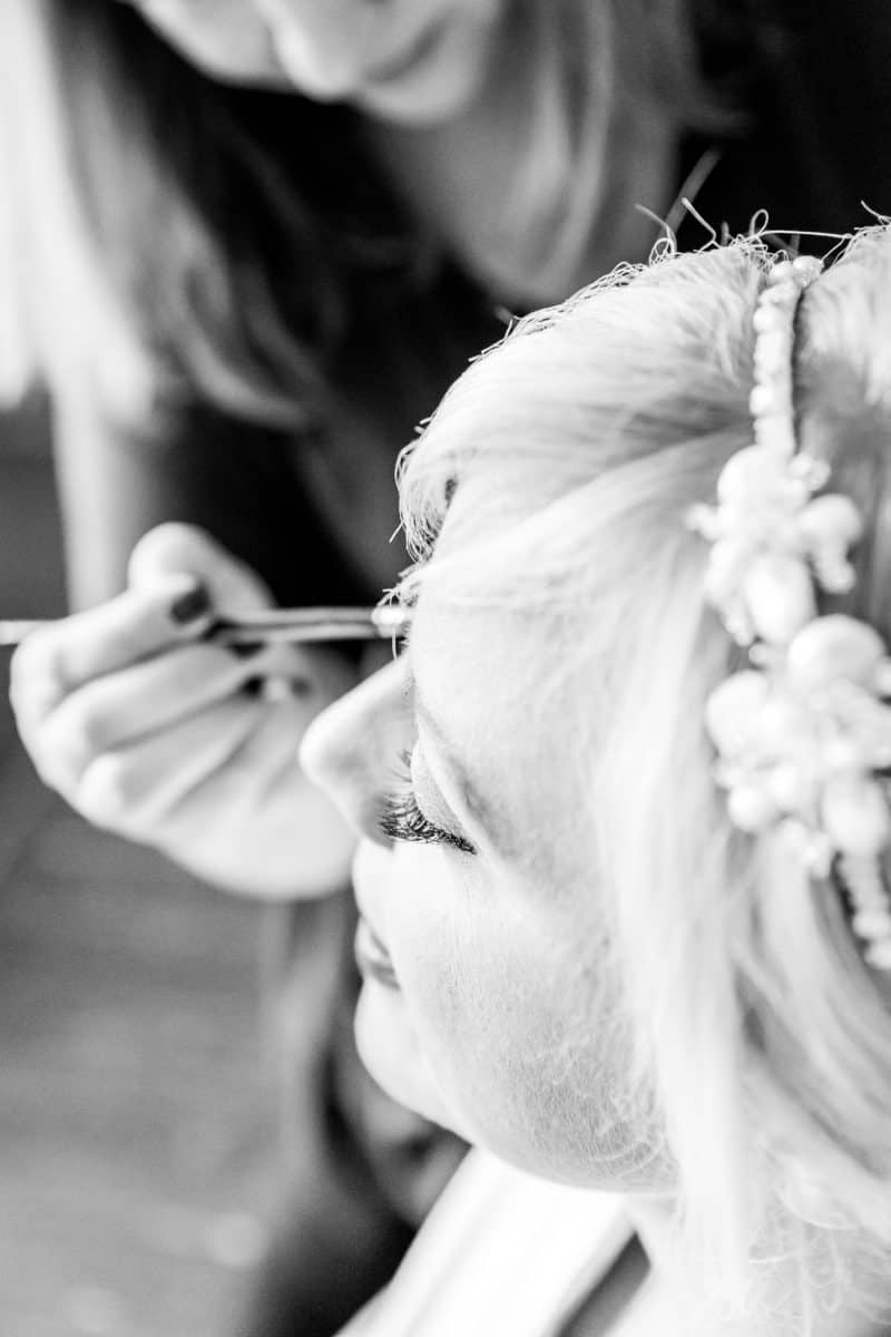 Black and white close up of bride having her make up professionally applied